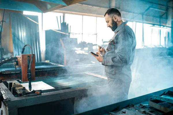 Trabalhador da indústria pesada que controla o processo de corte de metal — Fotografia de Stock