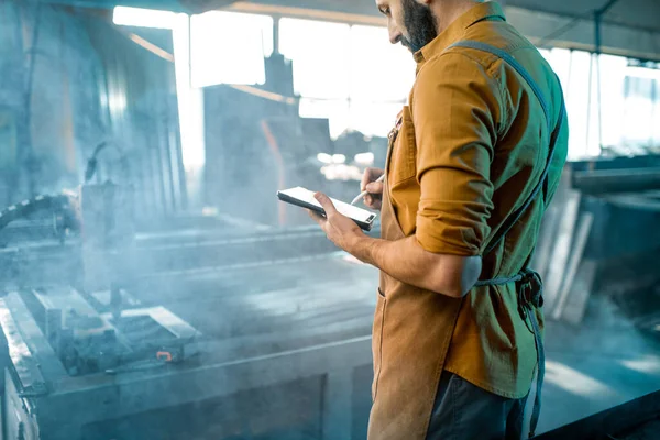 Heavy industry worker controlling the process of metal cutting — Stock Photo, Image