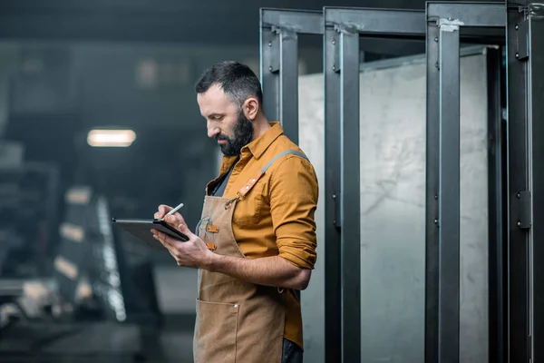 Trabalhador com um tablet digital na fábrica — Fotografia de Stock