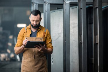 Fabrikada dijital tableti olan bir işçi.