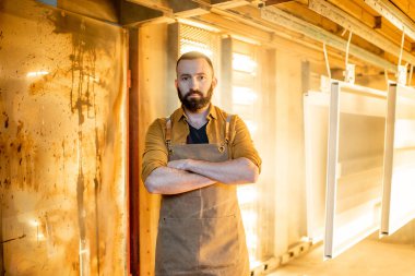 İşçi, boyanın kalitesini toz kaplama metal ürünleriyle kontrol ediyor