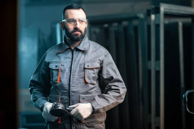 Adam atölyede metalle çalışıyor.