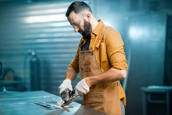 Homem trabalhando com metal na oficina — Fotografia de Stock