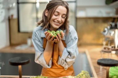 Mutfakta taze Brüksel lahanası olan bir kadın.