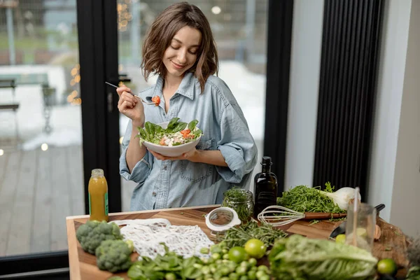 Evde sağlıklı yeşil salata yiyen bir kadın. — Stok fotoğraf