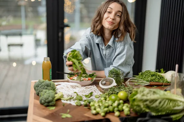 Mujer cocinando ensalada verde saludable en la cocina — Foto de Stock