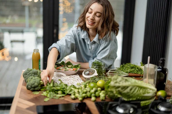Mujer cocinando ensalada verde saludable en la cocina — Foto de Stock