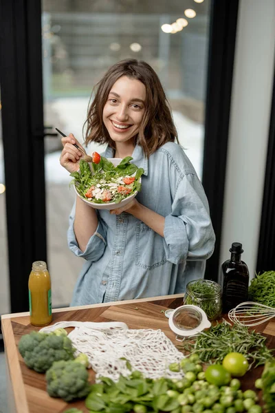 Femme mangeant une salade verte saine à la maison — Photo