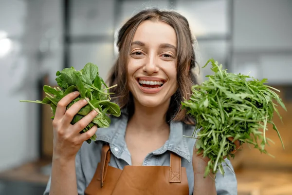 Kvinna med färska greener på köket — Stockfoto