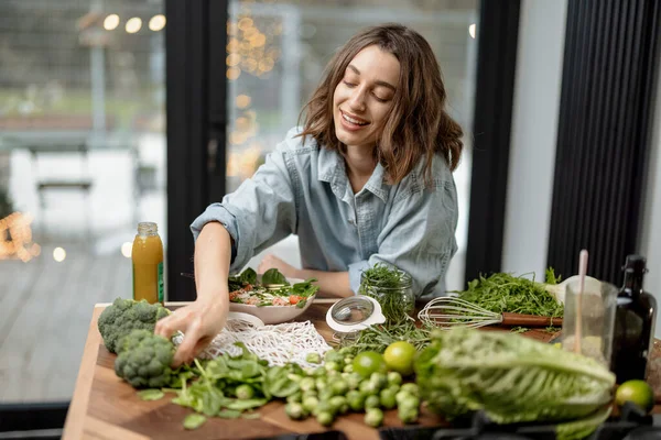 Mujer cocinando ensalada verde saludable en la cocina — Foto de Stock