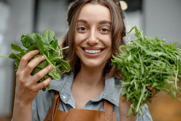Kvinna med färska greener på köket — Stockfoto
