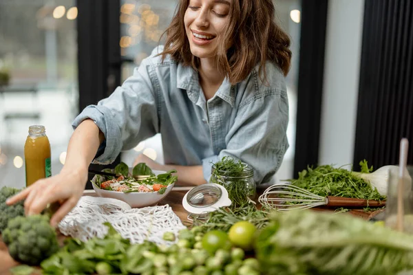 Γυναίκα μαγείρεμα υγιή πράσινη σαλάτα στην κουζίνα — Φωτογραφία Αρχείου