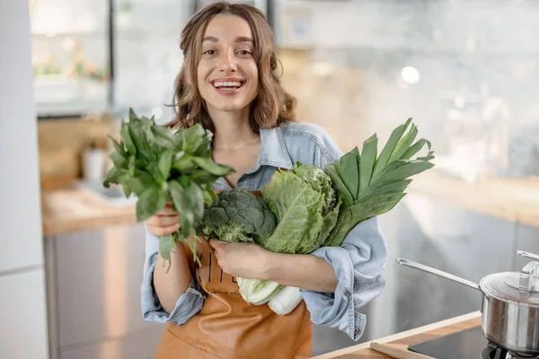 Mulher com legumes verdes frescos na cozinha — Fotografia de Stock