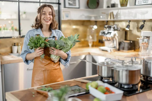 Mujer con verduras verdes frescas en la cocina — Foto de Stock