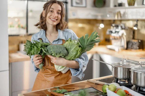 Mulher com legumes verdes frescos na cozinha — Fotografia de Stock