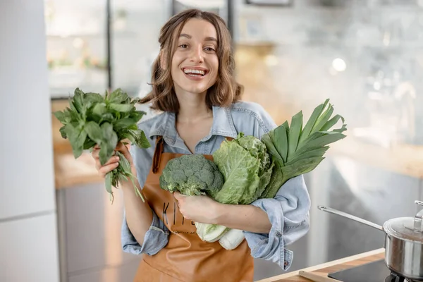 Mulher com legumes verdes frescos na cozinha — Fotografia de Stock