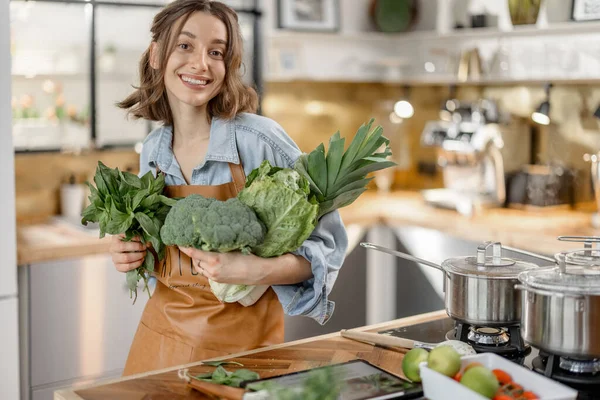 Mulher com legumes verdes frescos na cozinha — Fotografia de Stock