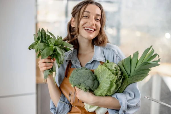 Mutfakta taze yeşil sebzeli bir kadın. — Stok fotoğraf