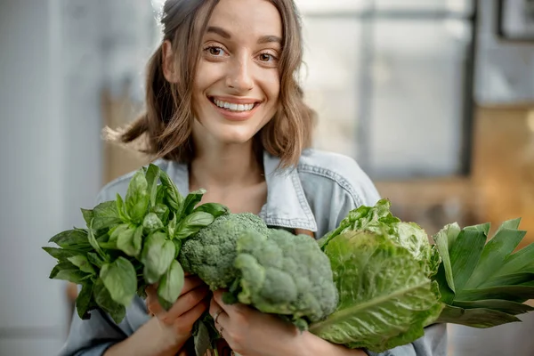 Kvinna med färska gröna grönsaker på köket — Stockfoto