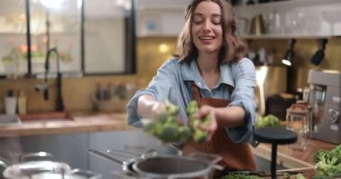 Kadın evde sağlıklı yemek pişiriyor.