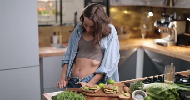 Slim woman with healthy food on the kitchen — Stock Video