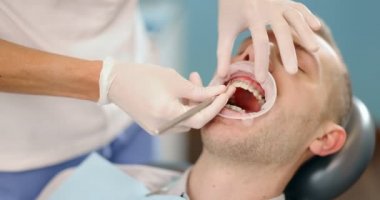 Düzenli bir ortodonti ziyareti sırasında diş teli takan hasta