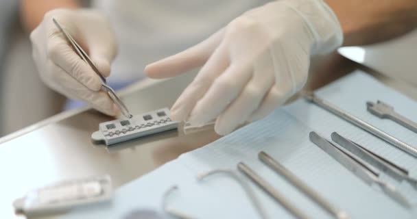 Ortodoncista trabajando con modelo de mandíbula aplicando sistema de ortodoncia — Vídeos de Stock