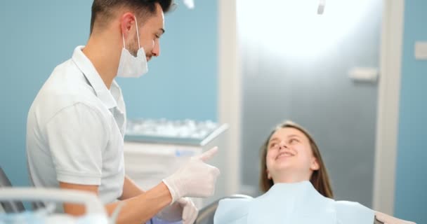 Счастливый дантист с молодым пациентом — стоковое видео