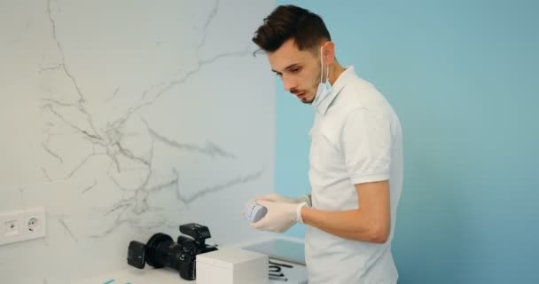 Dentista mostrando modelo de mandíbula para un paciente joven — Vídeos de Stock