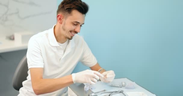 Стоматолог, який працює з моделлю зубів і зубних дужок — стокове відео