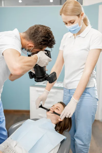 Dentista fotografando o resultado de seu trabalho — Fotografia de Stock