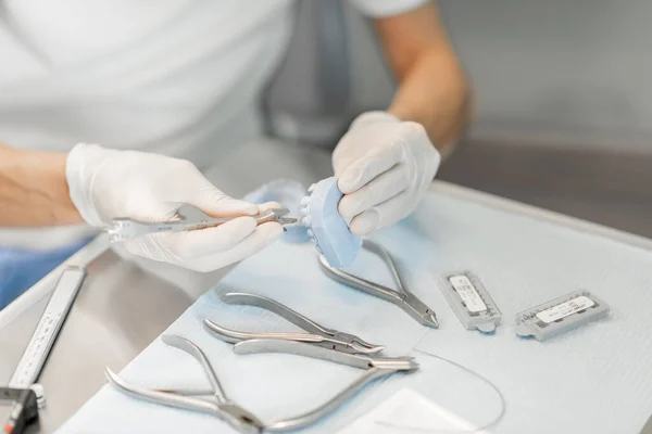 Técnico dental que trabaja con un modelo de dientes y aparatos dentales —  Fotos de Stock