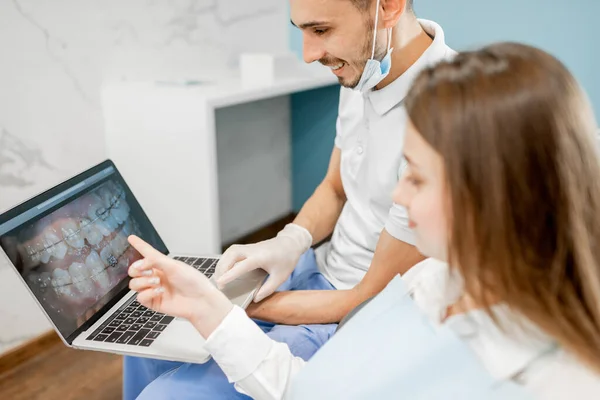 Dentist showing photo of teeth on a monitor for a young patient — Stock Photo, Image
