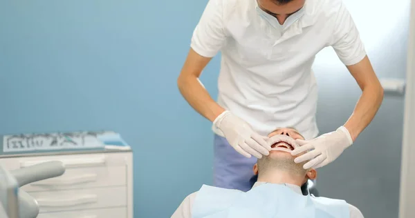 Dentista vistiendo oprimido para el paciente masculino, — Foto de Stock