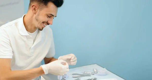Diş teknisyeni bir diş ve diş teli modeli üzerinde çalışıyor. — Stok fotoğraf