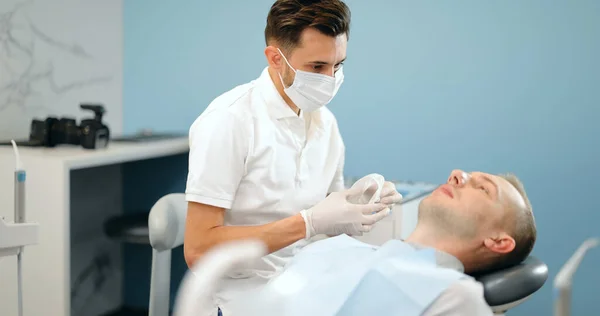 Dentista che indossa optragate per il paziente maschio, — Foto Stock