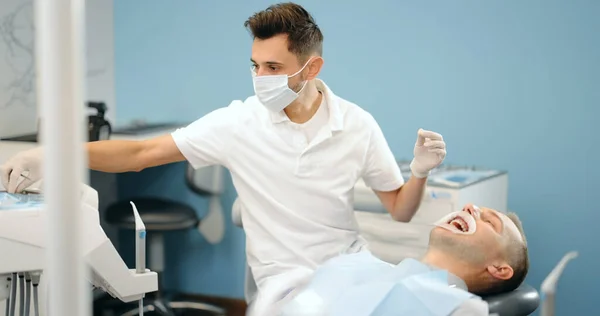 Стоматолог и пациент во время ортодонтического лечения — стоковое фото