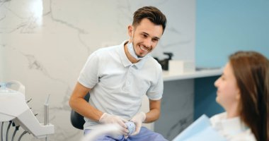 Genç bir hasta için çene modeli gösteren dişçi