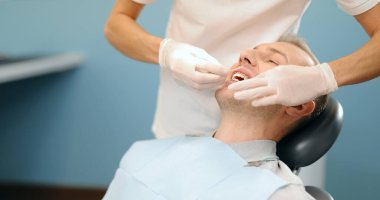 Diş muayenehanesindeki diş tellerindeki bağları değiştiren ortodontist