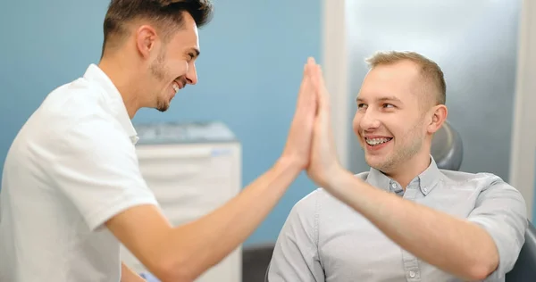 Happy male patient giving five to the dentist — Stock Photo, Image