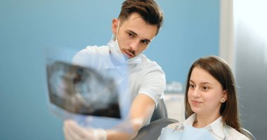 Genç bir hasta için çene röntgeni gösteren dişçi