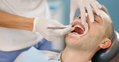 Düzenli bir ortodonti ziyareti sırasında diş teli takan hasta