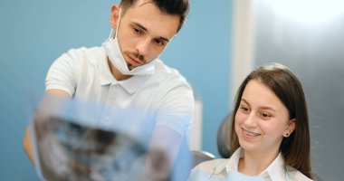 Genç bir hasta için çene röntgeni gösteren dişçi