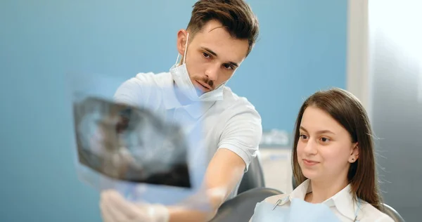 Dentysta pokazujący prześwietlenie szczęki młodemu pacjentowi — Zdjęcie stockowe