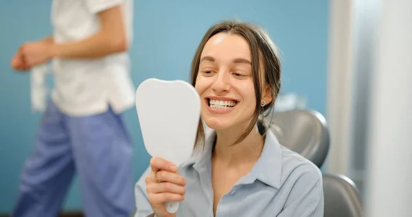 Frau glücklich mit haarsträubenden Zähnen in der Zahnarztpraxis — Stockfoto