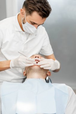 Düzenli bir ortodonti ziyareti sırasında diş teli takan hasta