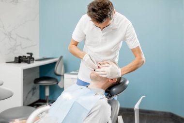 Düzenli bir ortodonti ziyareti sırasında diş teli takan hasta