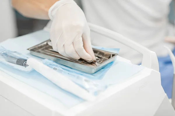 Dentista che prende strumenti dentali durante un trattamento medico — Foto Stock