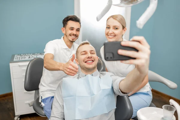 Patient heureux avec un dentiste au cabinet dentaire — Photo