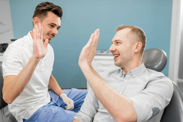 Happy male patient giving five to the dentist — Stock Photo, Image